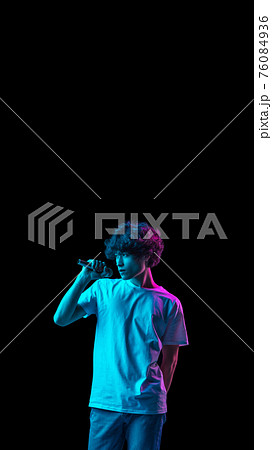 POrtrait of young Caucasian man singing isolated over dark background in neon POrtrait of young Caucasian man singing isolated over dark background in neon 76084936
