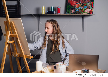 a young female student of an art school studies online remotely via the Internet. a young female student of an art school studies online remotely via the Internet. 76086246
