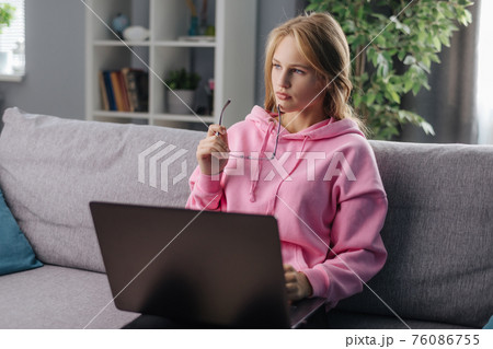 Woman using laptop on sofa Woman using laptop on sofa 76086755