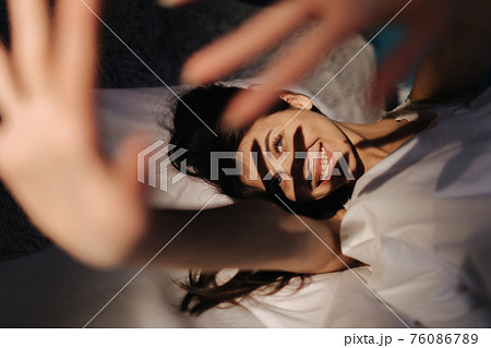 Sleepy woman in bed 76086789