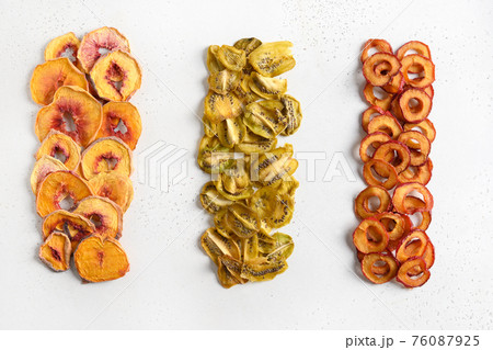 Plums, kiwi, peach chips as food background. Plums, kiwi, peach chips as food background. 76087925