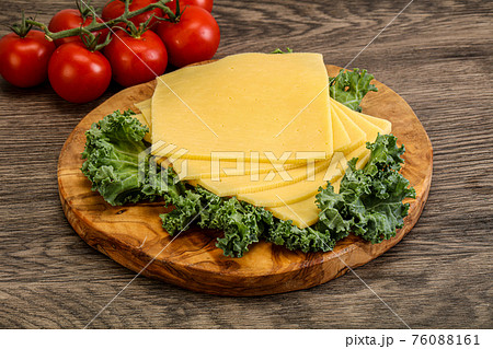 Sliced Gauda cheese over board 76088161