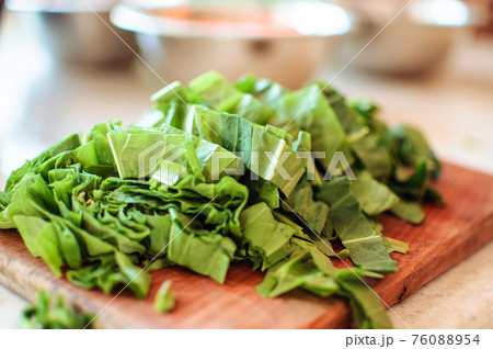 Young green sorrel sliced for borscht and salad lies on a cutting board, rustic style, in the morning in the sunlight. Copy space. 76088954