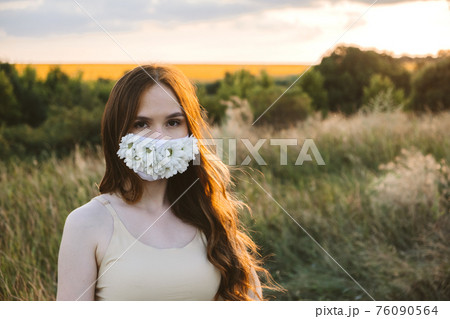 Wearing masks outdoors, Face Mask Reduce Allergy Symptoms. Outdoor portrait of woman in protective face Statement Masks with flowers on nature background Wearing masks outdoors, Face Mask Reduce Allergy Symptoms. Outdoor portrait of woman in protective face Statement Masks with flowers on nature background 76090564