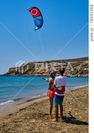 Trainer teaches woman to go kitesurfing on sea sand beach 76091068