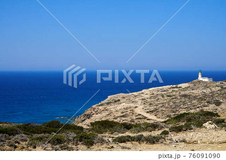 Beautiful lighthouse on a steep seashore against a calm sea background 76091090