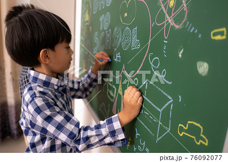 Asian littie boys write blackboard. 76092077