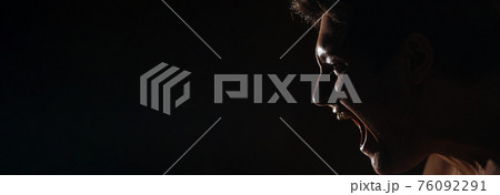 Caucasian man with a bared torso shouts on a dark background, banner, in a dark key, close-up 76092291