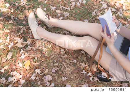 asian woman relax and read book under tree with pink flower on floor in spring season asian woman relax and read book under tree with pink flower on floor in spring season 76092614
