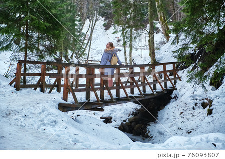 Caucasian woman walking on a long wooden bridgepedestrian wooden bridge Caucasian woman walking on a long wooden bridgepedestrian wooden bridge 76093807