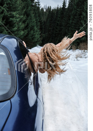 Young blonde in the car catching the wind, fast riding, travel 76093808