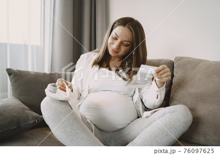 Pregnant woman looks at photo Pregnant woman looks at photo 76097625