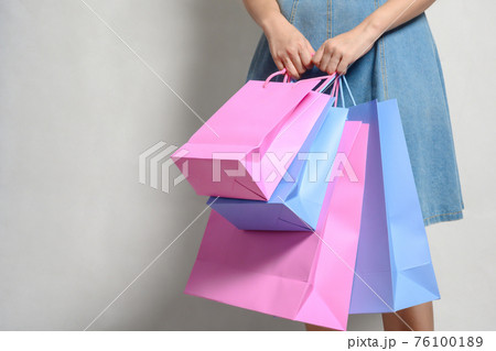 Young happy summer shopping woman with shopping bags isolated on grey background 76100189