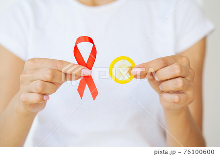 Woman hand holding red ribbon HIV, world AIDS day awareness ribbon. Woman hand holding red ribbon HIV, world AIDS day awareness ribbon. 76100600