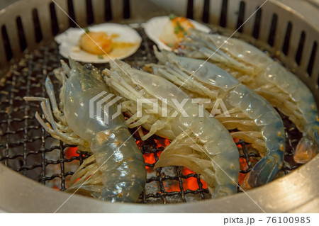 Raw fresh shrimp is grilled on a charcoal stove Raw fresh shrimp is grilled on a charcoal stove 76100985