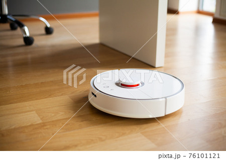 Vacuum cleaner robot runs on wood floor in a office Vacuum cleaner robot runs on wood floor in a office 76101121