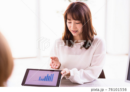 タブレットPCを持って話をするビジネスウーマン タブレットPCを持って話をするビジネスウーマン 76101556