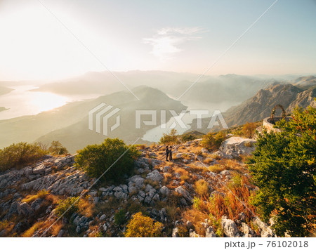 The bride and groom embracing on the Lovcen mountain behind them opens a view of the Bay of Kotor  76102018