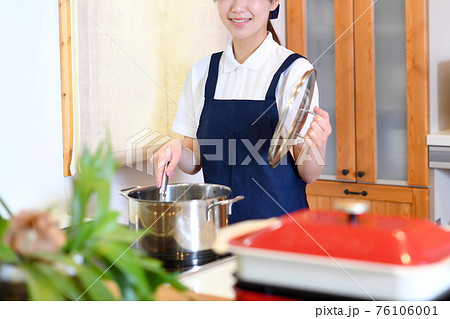 料理をするハウスキーパーの女性 料理をするハウスキーパーの女性 76106001