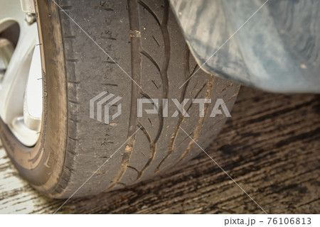 Old tire with worn tread and scratch 76106813