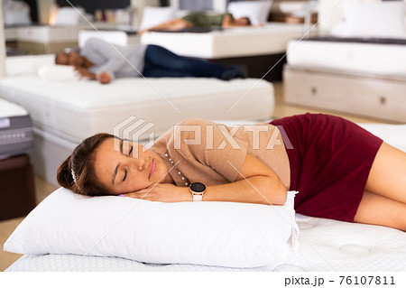 Young woman fell asleep on new mattress in furniture store Young woman fell asleep on new mattress in furniture store 76107811