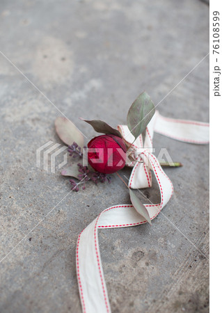 Red rose with ribbon on the concrete ground 76108599