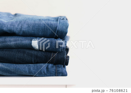 Stack of blue denim jean pants. Textile industry, clothing stores, sale concept. Stack of blue denim jean pants. Textile industry, clothing stores, sale concept. 76108621