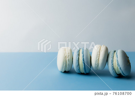 White and blue macaroons on the table, macaroons on blue background White and blue macaroons on the table, macaroons on blue background 76108700