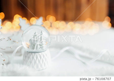 White christmas snow globe on a table with christmas decorations White christmas snow globe on a table with christmas decorations 76108707