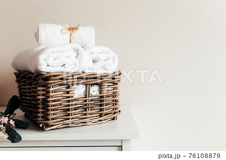 Basket with bathroom accessories. A set of rolled towels. Hotel cleaning concept 76108879