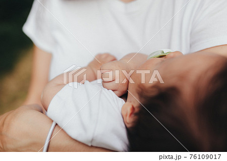 Little baby's hands, mother with baby, care of baby, mother carrying baby 76109017