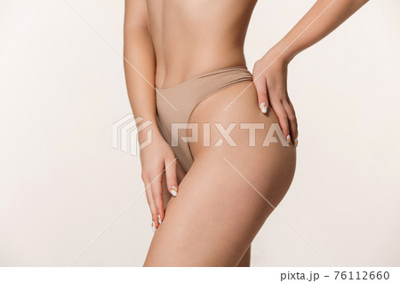 Sensual female body with well-kept skin in underwear over white background. Sensual female body with well-kept skin in underwear over white background. 76112660