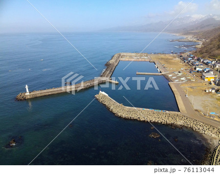 早春の北海道八雲町熊石地区の相沼漁港の風景を空撮 早春の北海道八雲町熊石地区の相沼漁港の風景を空撮 76113044