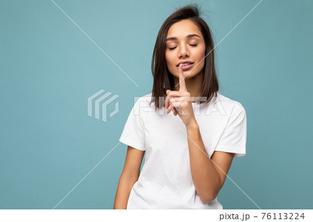 Portrait of positive young attractive brunette woman with sincere emotions wearing casual white t 76113224