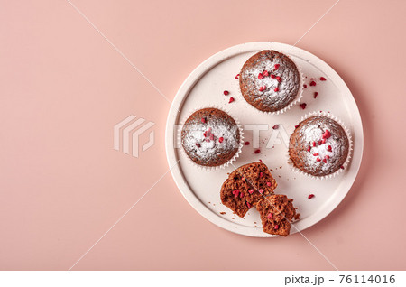 Homemade chocolate cupcakes in baking paper forms and piece of it Homemade chocolate cupcakes in baking paper forms and piece of it 76114016