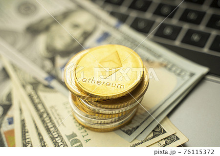 Ethereum coins on a dollars and on a laptop. Trading on the cryptocurrency exchange. Cryptocurrency Stock Market Concept. Mining or blockchain technology. Business concept. Ethereum coins on a dollars and on a laptop. Trading on the cryptocurrency exchange. Cryptocurrency Stock Market Concept. Mining or blockchain technology. Business concept. 76115372