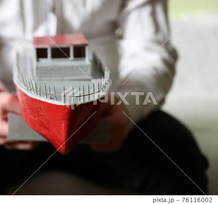 In the hands of the guy is a small motor boat. Handmade by a child. In the hands of the guy is a small motor boat. Handmade by a child. 76116002