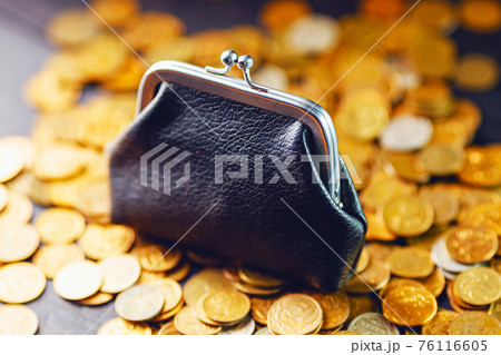 An old black wallet sits on top of a pile of yellow Russian coins. The concept of inflation and poverty. An old black wallet sits on top of a pile of yellow Russian coins. The concept of inflation and poverty. 76116605
