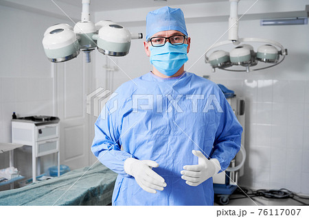 Male surgeon in medical mask standing in operating room. Male surgeon in medical mask standing in operating room. 76117007