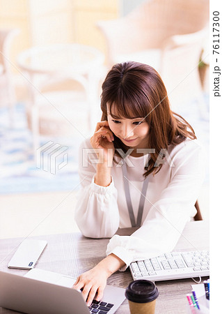 明るい室内でデスクワーク中の女性 明るい室内でデスクワーク中の女性 76117300