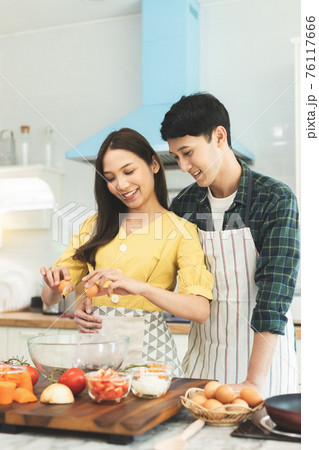 Portrait young couple in love helping to cook In a romantic atmosphere at home and looking at camera with smile face. Portrait young couple in love helping to cook In a romantic atmosphere at home and looking at camera with smile face. 76117666