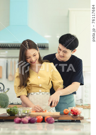 Portrait young couple in love helping to cook In a romantic atmosphere at home with smile face. Portrait young couple in love helping to cook In a romantic atmosphere at home with smile face. 76117684