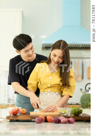 Portrait young couple in love helping to cook In a romantic atmosphere at home with smile face. Portrait young couple in love helping to cook In a romantic atmosphere at home with smile face. 76117685