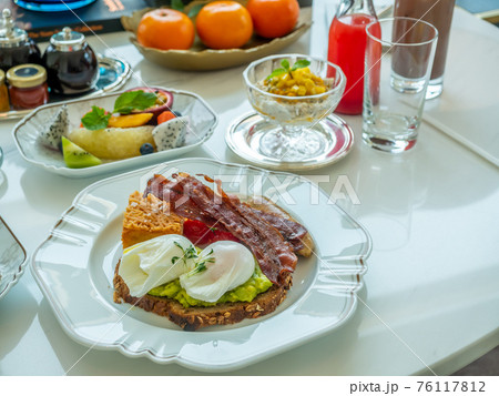 Breakfast set, fried egg, bacon, cereal, milk and pBreakfast set, fried egg, bacon, cereal, milk and pastry on elegant ceramic dish, served in luxuastry on elegant ceramic dish, served in luxury hotel Breakfast set, fried egg, bacon, cereal, milk and pBreakfast set, fried egg, bacon, cereal, milk and pastry on elegant ceramic dish, served in luxuastry on elegant ceramic dish, served in luxury hotel 76117812