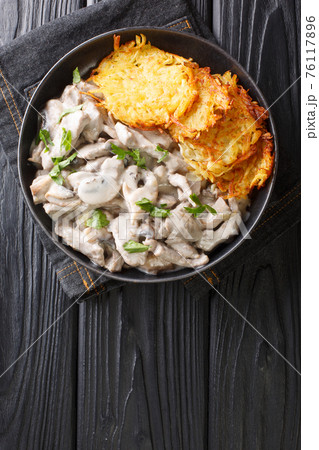 Zurich Ragout or Zurcher Geschnetzeltes Swiss simple ragout or stew recipe in a white sauce is made with mushrooms and white wine closeup in the plate. Vertical top view Zurich Ragout or Zurcher Geschnetzeltes Swiss simple ragout or stew recipe in a white sauce is made with mushrooms and white wine closeup in the plate. Vertical top view 76117896