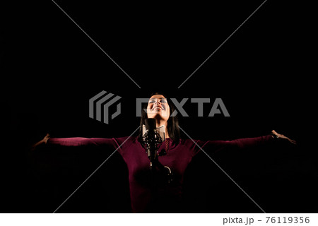Portrait of woman recording a song in a professional studio Portrait of woman recording a song in a professional studio 76119356