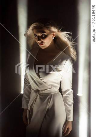 Woman club lights party background Dancing girl Long hair. Plus size artist posing in a beam of Woman club lights party background Dancing girl Long hair. Plus size artist posing in a beam of 76119440