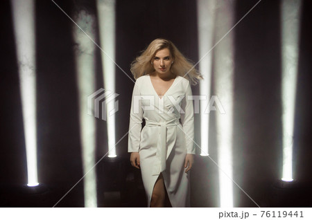 Woman club lights party background Dancing girl Long hair. Plus size artist posing in a beam of Woman club lights party background Dancing girl Long hair. Plus size artist posing in a beam of 76119441