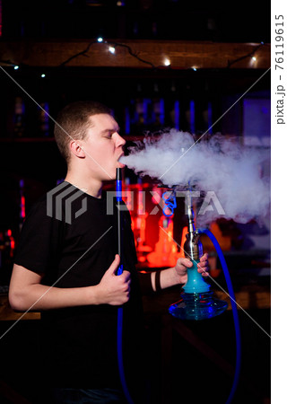 Man makes hookah. Modern hookah with coconut charcoal for relax and shisha smoke. 76119615