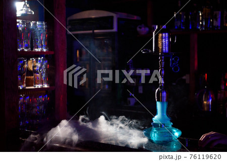 Hookah on the background of a bar, light, smoke, smog Hookah on the background of a bar, light, smoke, smog 76119620